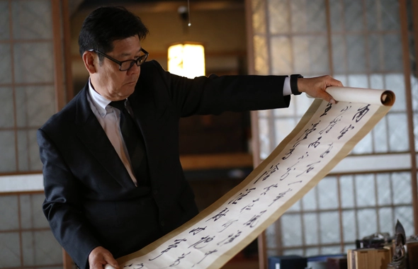 鑑定士が掛け軸を眺める様子